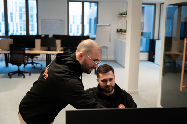 scène de travail dans un openspace entre un manager et un collaborateur